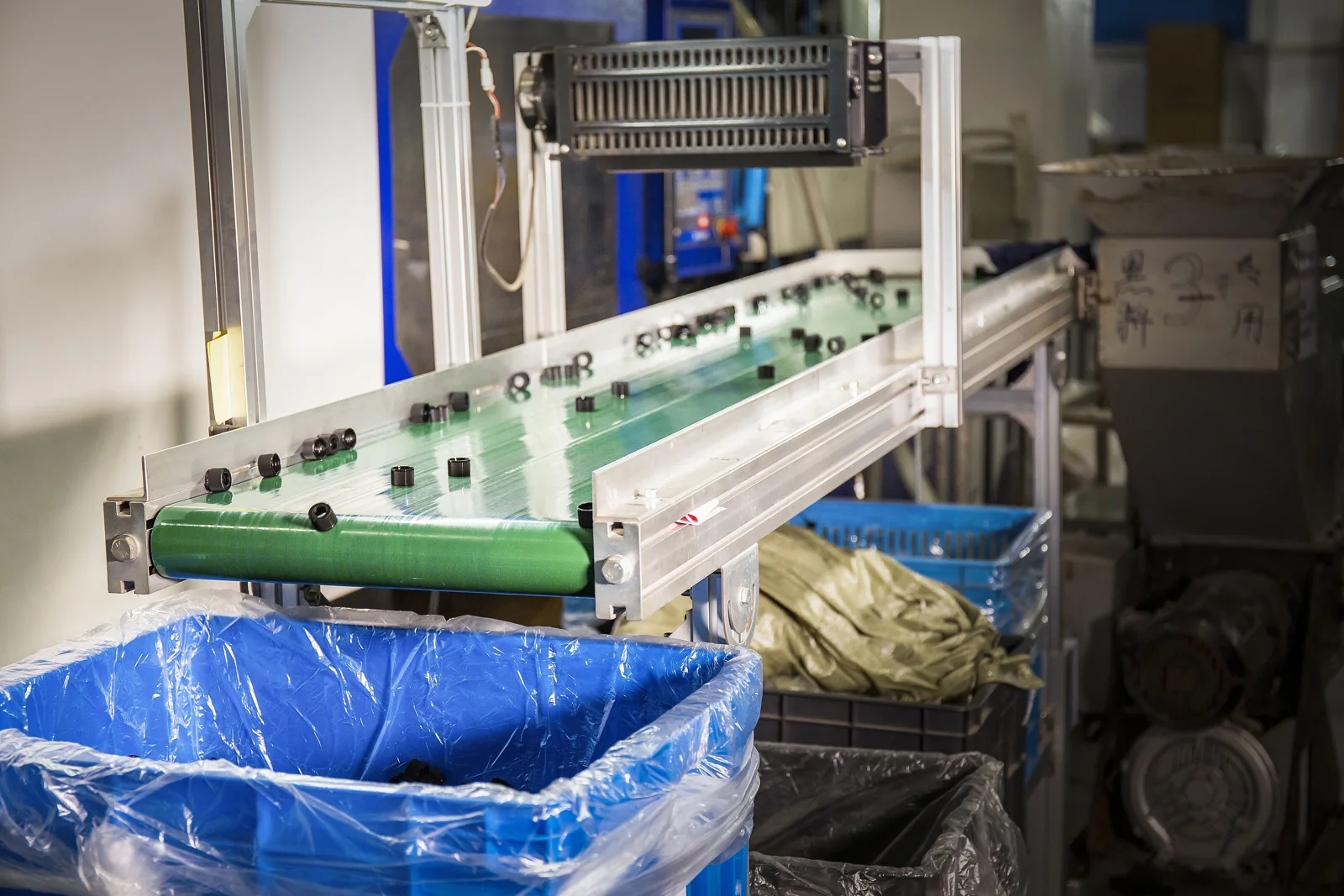 Conveyor beside injection molding equipment at Oulete
